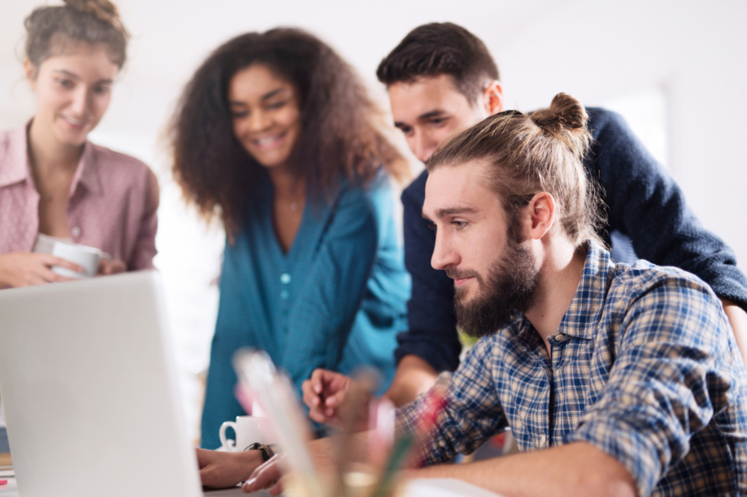 Un groupe d'étudiantes et d'étudiants regardent l'écran d'un ordinateur